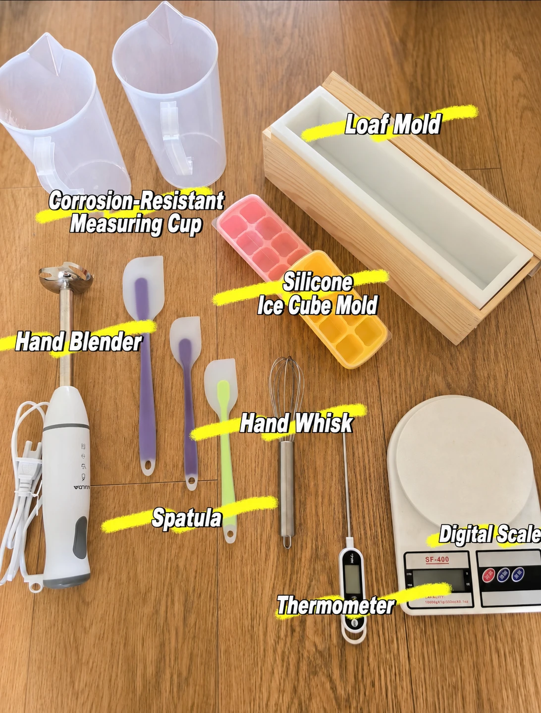 Handmade soap bars and soap making tools arranged on a wooden surface